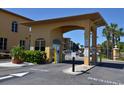 Community entrance featuring a gated entry, lush greenery, and visitor information booth at 4336 Bayside Village Dr # 201, Tampa, FL 33615