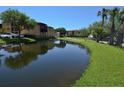 Scenic view of a tranquil pond reflecting the surrounding buildings and lush greenery at 4336 Bayside Village Dr # 201, Tampa, FL 33615