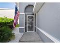 Front entry with a screened-in porch and American flag at 9288 New Orleans Dr, Weeki Wachee, FL 34613