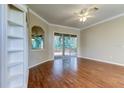 Living room with hardwood floors, built-in shelving, and sliding glass doors leading to a deck at 711 Wildflower Dr, Palm Harbor, FL 34683