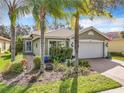 One-story house with a white garage door and landscaped yard at 15810 Cobble Mill Dr, Wimauma, FL 33598