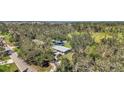 Aerial view showcasing a single-story house, a paved driveway, and lush green surroundings at 12020 82Nd E St, Parrish, FL 34219