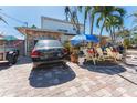 Brick paved front yard with tropical landscaping and seating at 14180 W Parsley Dr, Madeira Beach, FL 33708