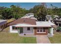 Newly renovated home with a modern exterior, featuring a green door and brown accents at 1328 Barry St, Clearwater, FL 33756