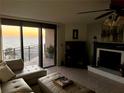 Cozy living room with tile flooring, fireplace, and ocean view balcony access at 2618 Gulf Blvd # 407, Indian Rocks Beach, FL 33785
