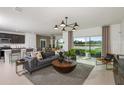 Open living room featuring stylish furniture, modern lighting, and views of the lake at 6674 Michael Favor Way, Wesley Chapel, FL 33545