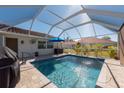 Inviting screened-in pool with clear water, a blue umbrella, and ample patio space at 701 Westmont Way, Sun City Center, FL 33573