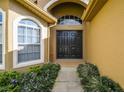 Double door entry with arched windows and landscaping at 448 Greenwich Cir, Spring Hill, FL 34609