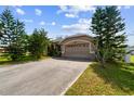 Tan house with a two-car garage and mature landscaping at 8601 Atmore Ave., North Port, FL 34287