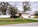 Well-kept single-story home with manicured lawn, an attached two-car garage, and privacy fence at 802 Highgate Oaks Pl, Seffner, FL 33584
