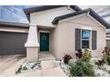 House exterior with teal front door and landscaping at 14906 Imperial Purple Ln, Wimauma, FL 33598