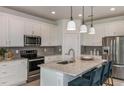 Modern kitchen with white cabinets, granite island, and stainless steel appliances at 6659 Michael Favor Way, Wesley Chapel, FL 33545