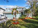 Two-story house with light teal exterior, landscaping, and a two-car garage at 5009 Clover Mist Dr, Apollo Beach, FL 33572