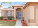 Front entry with a blue door, walkway, and landscaping at 6340 Sushi Ct, Wesley Chapel, FL 33545