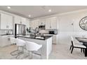 Modern kitchen featuring white cabinets, a large kitchen island with seating, and marble flooring at 31885 Anchor Point Dr, Wesley Chapel, FL 33545
