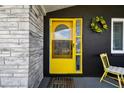 Bright yellow front door adds a cheerful vibe to the home's exterior at 2617 Society Dr, Holiday, FL 34691