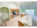 A kitchen features a spacious island, tile floors, stainless steel appliances and light-colored cabinets at 2857 Brewster Rd, North Port, FL 34288