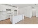 Open kitchen with a center island, ample white cabinetry, and stainless steel appliances at 6741 Michael Favor Way, Wesley Chapel, FL 33545