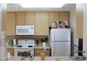 Cozy kitchen with light wood cabinets and white appliances at 4460 95Th N Ave # 1, Pinellas Park, FL 33782