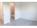 An all-white bedroom shows access to the modern bathroom at 1218 E Kay St # 3, Tampa, FL 33602