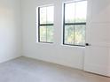 A clean bedroom with sleek concrete floors and bright natural light at 1218 E Kay St # 3, Tampa, FL 33602