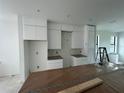 White kitchen with white cabinetry, marble backsplash, and under-mount sink at 1302 E Kay St # 1, Tampa, FL 33602