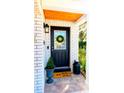 Black front door with wreath and decorative mat at 10931 Clara Ln, St Petersburg, FL 33708