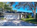 Brick ranch home with attached garage and mature landscaping at 10931 Clara Ln, St Petersburg, FL 33708