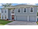 Two-story house with gray siding, red door, and two-car garage at 8378 Gibralter St, Spring Hill, FL 34608