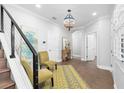 Elegant foyer with hardwood floors, staircase, stylish lighting, and neutral decor, creating a welcoming entrance at 5902 Yeats Manor Dr, Tampa, FL 33616
