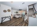 Open living area with wood-look floors, a comfy couch, and stairs at 2444 Foggy Creek Cir, Clearwater, FL 33764