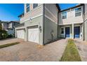 Townhome exterior showcasing a two-car garage and a paved driveway at 2444 Foggy Creek Cir, Clearwater, FL 33764