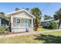 Charming bungalow with a teal door and white porch at 1325 W North B St, Tampa, FL 33606