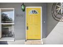 Inviting yellow front door with a circular window at 8010 N Lynn Ave, Tampa, FL 33604