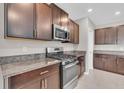 Modern kitchen with dark cabinets, granite counters, and stainless steel appliances at 5432 Rainwood Meadows Dr, Apollo Beach, FL 33572