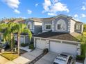 Two-story townhome with gray exterior, two-car garage, and palm trees at 18151 Nassau Point Dr, Tampa, FL 33647