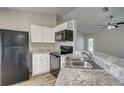 Modern kitchen features white cabinets, black appliances, and granite countertops at 3776 Junction St, North Port, FL 34288
