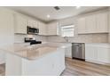 Modern kitchen with white cabinets, quartz countertops and stainless steel appliances at 9809 Crescent Moon Dr, Riverview, FL 33578