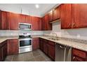 Modern kitchen with dark wood cabinets, granite counters, and stainless steel appliances at 8448 Red Roe Dr, New Port Richey, FL 34653