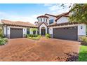 Two-story home with a three-car garage and brick driveway at 8414 Dunham Station Dr, Tampa, FL 33647