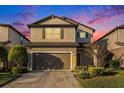 Two-story house with neutral siding, a brown garage door, and landscaping at 7779 Yale Harbor Dr, Wesley Chapel, FL 33545