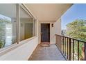 Bright condo entryway with private balcony, featuring a black door and large windows at 2699 Seville Blvd # 303, Clearwater, FL 33764