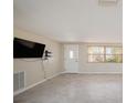 Bright living room with tile flooring, a front door, and neutral paint at 5346 Quist Dr, Port Richey, FL 34668