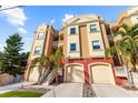 Three-story building with three-car garage and stucco exterior at 120 Brightwater Dr # 2, Clearwater Beach, FL 33767