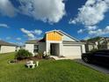 Charming one-story house with a two-car garage and landscaped front yard at 12730 Mangrove Forest Dr, Riverview, FL 33579