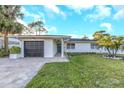 Charming single-story home with a well-manicured lawn, attached garage, and inviting entryway at 4518 Helena Ne St, St Petersburg, FL 33703