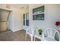 Inviting front porch featuring tile flooring, white chairs, and a view of the building's exterior at 6061 Bahia Del Mar Cir # 241, St Petersburg, FL 33715