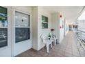 Inviting front porch featuring tile flooring, white chairs, and a view of the building's exterior at 6061 Bahia Del Mar Cir # 241, St Petersburg, FL 33715