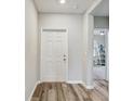 Bright entryway with white door and wood-look flooring at 9702 Sage Creek Dr, Sun City Center, FL 33573