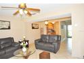 Bright living room boasts tile floors, ceiling fan, and an open layout flowing into the kitchen area at 117 114Th N Ave # 117, St Petersburg, FL 33716